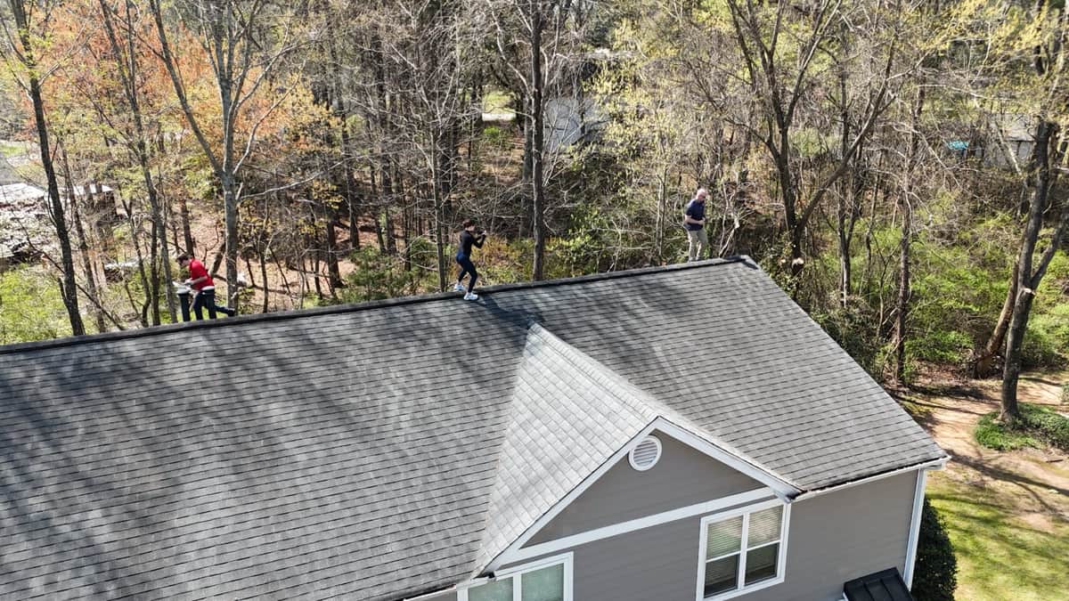 Capital City Roofing team inspecting a residential roof from the ridge